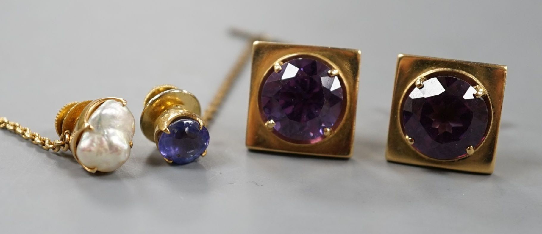 A modern pair of 750 yellow metal and synthetic colour change corundum set cufflinks, a yellow metal and sapphire set pin and similar baroque pearl set pin